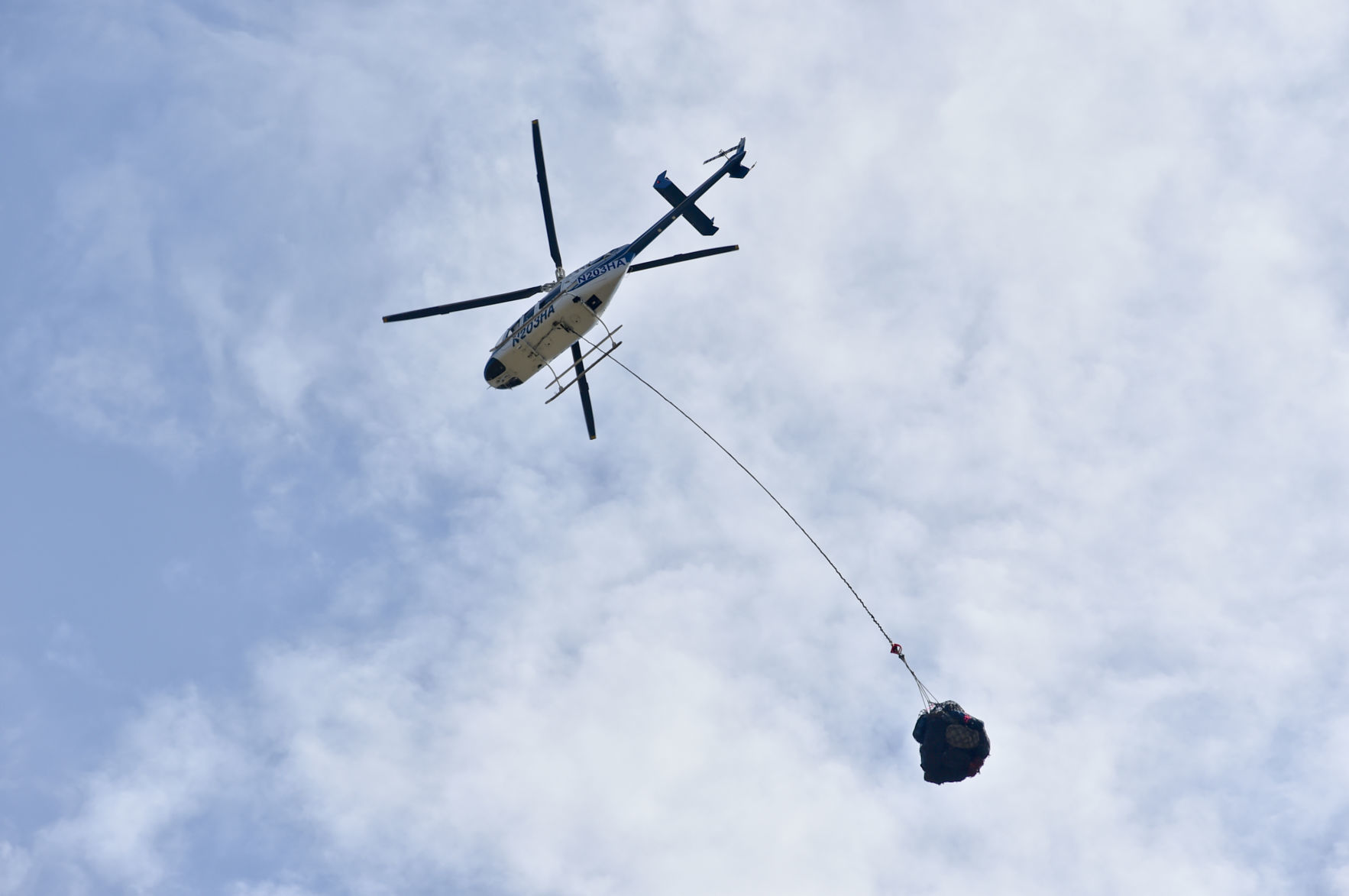 A helicopter flies equipment in